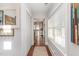 Bright hallway featuring hardwood floors, large windows, and closet with easy access to the kitchen at 109 N Watauga Ave, Dunn, NC 28334