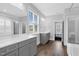 Bright bathroom with double vanity, large window, and walk-in shower with subway tile at 1124 Cedar Farm Trl, Fuquay Varina, NC 27526