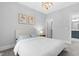 Bedroom features neutral walls, trim, and carpet; modern light fixture and connects to bathroom at 1124 Cedar Farm Trl, Fuquay Varina, NC 27526