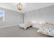 Large bedroom with neutral walls, carpet, and trim; features a modern light fixture at 1124 Cedar Farm Trl, Fuquay Varina, NC 27526