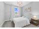 Bedroom features natural light, neutral walls, carpet and trim, and a modern chandelier at 1124 Cedar Farm Trl, Fuquay Varina, NC 27526