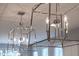 Chrome dining room chandelier fixture with candle-like bulbs illuminates the kitchen island at 1124 Cedar Farm Trl, Fuquay Varina, NC 27526