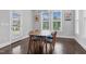 Dining room features hardwood floors, abundant natural light, and contemporary chandelier at 1124 Cedar Farm Trl, Fuquay Varina, NC 27526