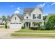 Charming two-story home with a well-manicured lawn, lush landscaping, and a welcoming entrance at 1124 Cedar Farm Trl, Fuquay Varina, NC 27526