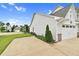 Exterior side view of a white home with a two-car garage and green yard at 1124 Cedar Farm Trl, Fuquay Varina, NC 27526