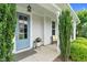 Inviting front porch with a blue door, manicured greenery, and a cozy seating area at 1124 Cedar Farm Trl, Fuquay Varina, NC 27526