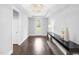 Bright hallway with hardwood floors, chandelier, console table, and an exterior door at 1124 Cedar Farm Trl, Fuquay Varina, NC 27526