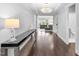 Bright hallway with hardwood floors, chandelier, console table, and an open view to the living room at 1124 Cedar Farm Trl, Fuquay Varina, NC 27526