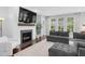 Cozy living room with fireplace, large TV, and ample natural light through large windows at 1124 Cedar Farm Trl, Fuquay Varina, NC 27526