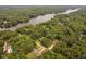 Aerial view showcasing the property nestled amongst mature trees, with a glimpse of a serene lake nearby at 114 Crow Dr, Louisburg, NC 27549