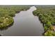 Aerial view showcasing a serene lake bordered by lush trees and charming lakefront homes, creating a peaceful landscape at 114 Crow Dr, Louisburg, NC 27549