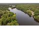 Aerial view of a tranquil lake surrounded by lush green trees, dotted with lakefront homes and docks at 114 Crow Dr, Louisburg, NC 27549
