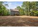 Two-story house shows spacious backyard with new grass beginning to sprout, surrounded by mature trees at 114 Crow Dr, Louisburg, NC 27549