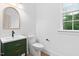 Powder room with green vanity, round mirror, and window at 114 Crow Dr, Louisburg, NC 27549