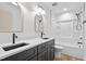Modern bathroom features a dual sink vanity, sleek mirrors, and a shower-tub combo at 114 Crow Dr, Louisburg, NC 27549