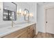 Modern bathroom features double sinks, stylish mirrors with sconces, and wood look floors at 114 Crow Dr, Louisburg, NC 27549