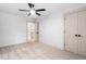 Bright, carpeted bedroom with ceiling fan and closet; door opens to a staircase at 114 Crow Dr, Louisburg, NC 27549