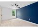 Bedroom featuring a dark blue accent wall, neutral carpet, and a ceiling fan at 114 Crow Dr, Louisburg, NC 27549