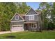 Charming two-story home featuring a garage, complemented by a well-manicured lawn and mature trees at 114 Crow Dr, Louisburg, NC 27549