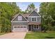 Charming two-story home featuring a garage, complemented by a well-manicured lawn and mature trees at 114 Crow Dr, Louisburg, NC 27549