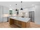 Bright kitchen with white cabinets, stainless appliances, light countertops and center island at 114 Crow Dr, Louisburg, NC 27549
