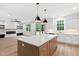 Bright kitchen with white cabinets, stainless appliances, light countertops and center island at 114 Crow Dr, Louisburg, NC 27549