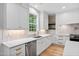 Bright kitchen with white cabinets, stainless appliances, light countertops and view to window at 114 Crow Dr, Louisburg, NC 27549