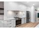 Bright kitchen with white cabinets, stainless appliances, light countertops and tile backsplash at 114 Crow Dr, Louisburg, NC 27549