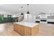 Bright kitchen with light wood island, wood floors, and connecting view to Gathering room at 114 Crow Dr, Louisburg, NC 27549