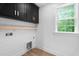 Bright laundry room features built-in cabinets, wood shelf, and a window for natural light at 114 Crow Dr, Louisburg, NC 27549