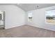 Bright bedroom with neutral carpet, two large windows, and ensuite bathroom access at 11640 International Dr, Middlesex, NC 27557