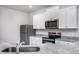 Modern kitchen featuring stainless steel appliances, ample counter space, and sleek white cabinets at 11640 International Dr, Middlesex, NC 27557