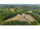 Expansive aerial view of a property showcasing open fields and mature trees, a serene and natural landscape at 1167 John D Winstead Rd, Roxboro, NC 27574