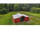 Aerial view of a well-maintained metal barn surrounded by a fenced green pasture at 1167 John D Winstead Rd, Roxboro, NC 27574
