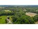 Expansive aerial view of lush acreage with home, barns, and cultivated fields surrounded by dense woodland at 1167 John D Winstead Rd, Roxboro, NC 27574