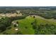 Expansive aerial view of property with lush forests, green fields, and a scattering of homes at 1167 John D Winstead Rd, Roxboro, NC 27574