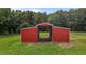 A bright red metal barn stands ready, perfect for agricultural or storage needs at 1167 John D Winstead Rd, Roxboro, NC 27574