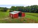 Elevated shot showcasing a vivid red metal barn, set against a backdrop of lush trees at 1167 John D Winstead Rd, Roxboro, NC 27574