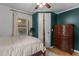 Bedroom featuring a four-poster bed, dark green accent wall, hardwood floors, and bright natural light at 1167 John D Winstead Rd, Roxboro, NC 27574
