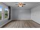 Spacious bedroom with neutral paint, updated flooring, and a large window overlooking the front yard at 1167 John D Winstead Rd, Roxboro, NC 27574