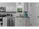 The renovated kitchen offers new cabinets, stainless appliances, and plenty of light at 1167 John D Winstead Rd, Roxboro, NC 27574