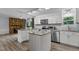 Bright kitchen features stainless appliances, granite counters, white cabinetry, and a stone accent wall with fireplace at 1167 John D Winstead Rd, Roxboro, NC 27574