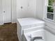 Bathroom featuring a white tub with chrome faucet, window and tile flooring at 120 Point Harbor Dr, Cary, NC 27519
