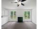 Bright living room with fireplace, ceiling fan, and large windows offering lots of natural light at 120 Point Harbor Dr, Cary, NC 27519