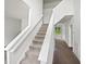 Bright and airy staircase featuring neutral carpeting and white risers with a view toward the entry at 120 Point Harbor Dr, Cary, NC 27519