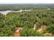 Aerial view of wooded neighborhood with a lake in the background with two new homes under construction at 125 Oswego Dr, Louisburg, NC 27549