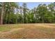 Expansive backyard shows a large green field surrounded by mature trees at 125 Oswego Dr, Louisburg, NC 27549