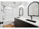 Modern bathroom featuring double sinks with black fixtures and a tub with shower combo at 125 Oswego Dr, Louisburg, NC 27549