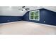 Attic bedroom features blue accent walls, a ceiling fan, and a window providing natural light at 125 Oswego Dr, Louisburg, NC 27549