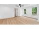 Bright bedroom with hardwood floors, two windows, a ceiling fan, and white trim at 125 Oswego Dr, Louisburg, NC 27549